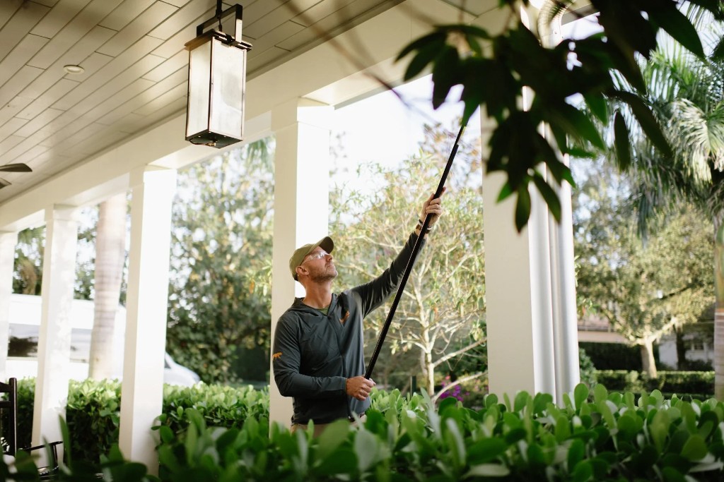 Panther Pest Control technician inspecting and treating a residential porch