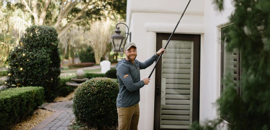 Panther Pest Control technician treating the exterior of a Florida home